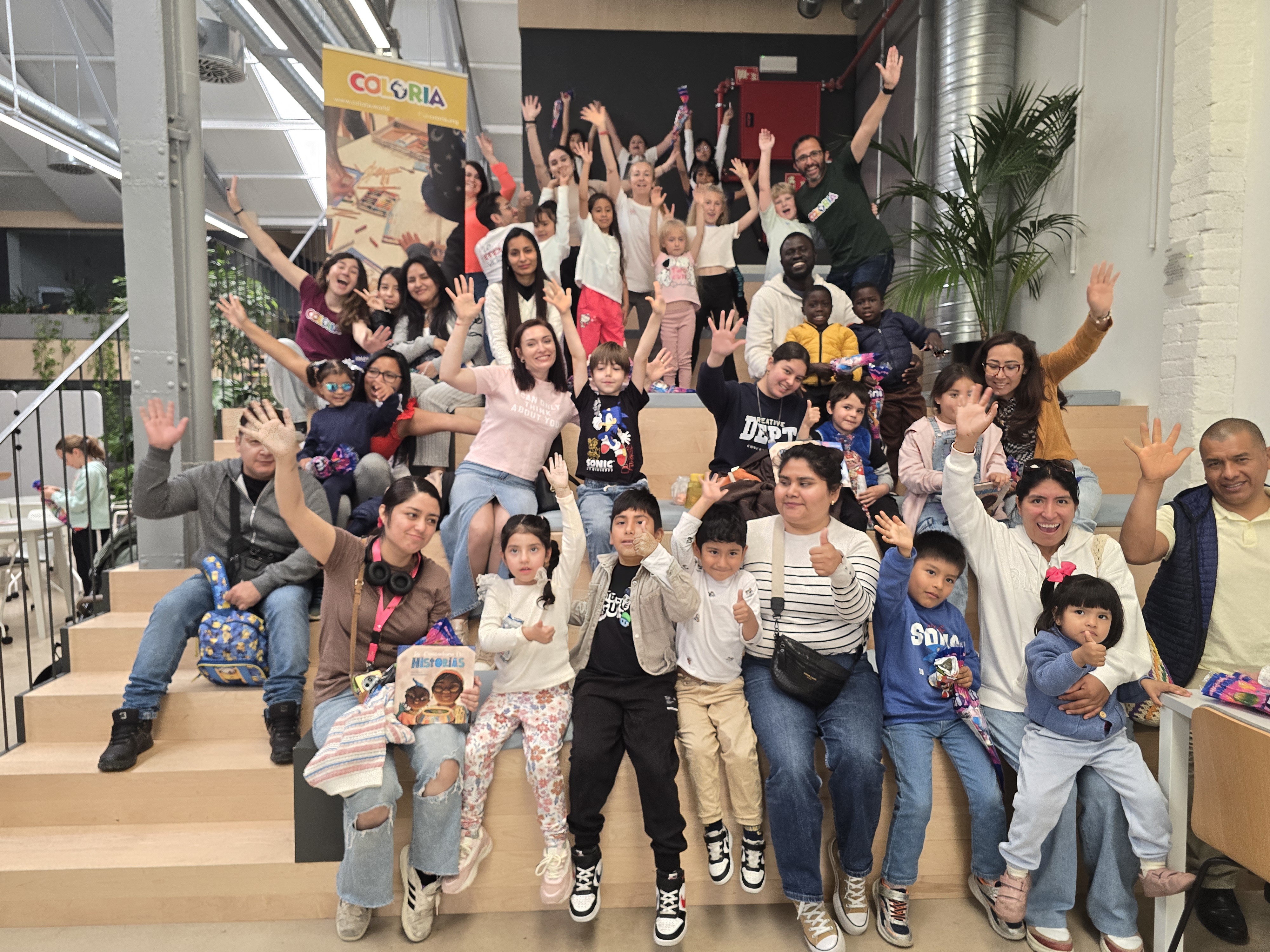 Niños y voluntarios celebrando juntos el éxito de la jornada especial de Coloria.